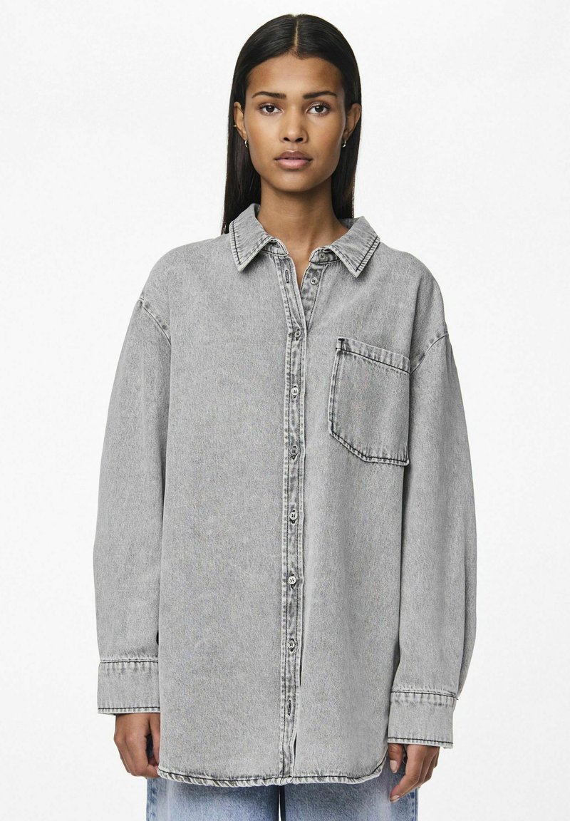Gray denim shirt with a collared neckline, long sleeves, front button closure, and a chest pocket. Features a relaxed fit and slightly faded texture.