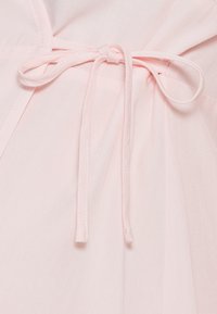 Tecido rosa claro com uma textura suave, featuring um laço na cintura e detalhes de design plissado. O laço está colocado centralmente.