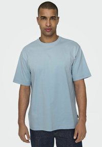 Hellblaues, kurzärmliges T-Shirt aus weichem Stoff mit Rundhalsausschnitt. Bietet eine lässige Passform und dezente Nähte.