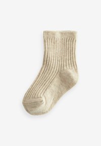 Beige gerippte Socke mit weicher Textur, abgerundetem Zehenbereich und dehnbarem Bündchen. Das Design zeigt vertikale Linien im gesamten Stoff.