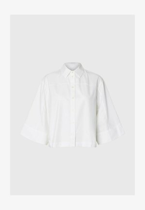 Weißes Hemd mit Knöpfen, breiten dreiviertel Ärmeln und klassischem Kragen, flach auf einem hellgrauen Hintergrund dargestellt.