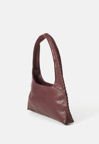 Bordeaux læder håndtaske med en glat tekstur, unik skulderrem med fletdetalje og et minimalistisk design.