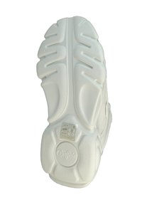 White sneaker sole with thick, textured rubber, deep treads, and a circular logo at the heel. Includes care instructions on a tag.