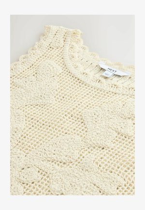 Kermanvärinen virkattu neulepaita, jossa kukkakuvioita ja aaltoileva pääntie, esillä valkoinen Next-merkkinen etiketti.