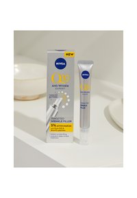 NIVEA Q10 Anti-Falten-Experte gezielter Faltenfüller in einer silbernen Tube neben einer Produktverpackung mit gelben und blauen Texten und Grafiken.
