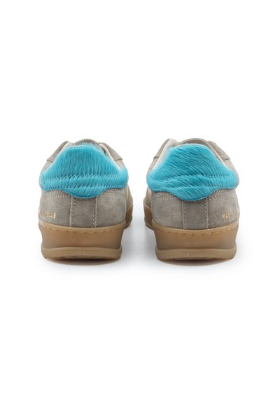 Paire de baskets en daim gris avec semelles en gomme et accents de fourrure bleu vif sur le talon, vue de dos sur fond blanc.