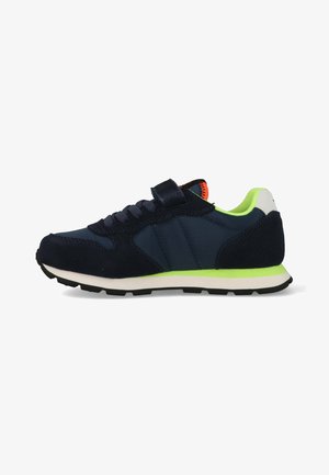 Navy blue and black sneaker with neon green accents, black laces, a velcro strap, and a white sole with black tread viewed from the side.