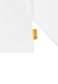 Weißes Baumwollshirt mit kurzen Ärmeln. Verfügt über ein kleines gelbes Etikett mit pinkem Text und Logo an der Seite. Glatte Textur, normale Passform.