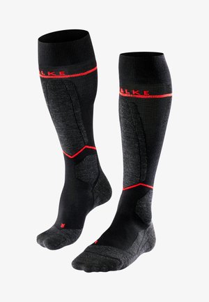 Schwarze knielange Socken mit einem strukturierten Design, ausgestattet mit roten Akzenten und verstärkten Bereichen für erhöhte Haltbarkeit. Hergestellt aus synthetischem Material.