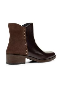 Stivale alla caviglia con parte anteriore in pelle marrone scuro, retro in camoscio, piccole borchie metalliche lungo la cucitura e tacco basso a scatola.