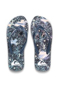 Et par flip-flops med mørkeblå stropper og tropisk blomsterprint på sålerne, der har et hvidt logo nær tæerne på en hvid baggrund.