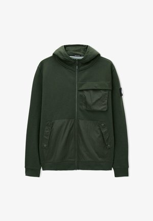 Hanorac cu fermoar de culoare verde închis, cu glugă, buzunar mare cu clapetă pe pieptul stâng și două buzunare cu capse în partea inferioară frontală.