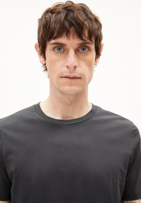 Dunkelgraues Baumwoll-T-Shirt mit rundem Halsausschnitt und kurzen Ärmeln, das eine glatte Textur aufweist und keine sichtbaren Muster oder Grafiken hat.