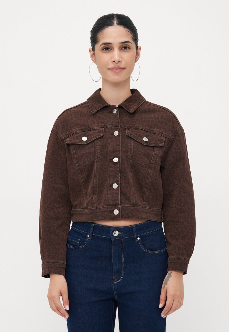 Bruine, cropped spijkerjas met een luipaardprint, knoopsluiting, twee borstzakken en zilverkleurige accenten. Draagt met donkerblauwe jeans.