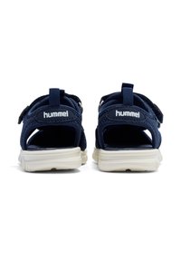 Navy blue sandals with open backs, featuring hook-and-loop straps, mesh fabric, and a cushioned white rubber sole.