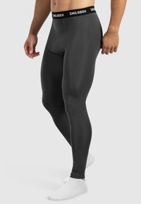 Zwarte sportleggings van rekbaar materiaal, met een aansluitend ontwerp en een merkband met witte letters.