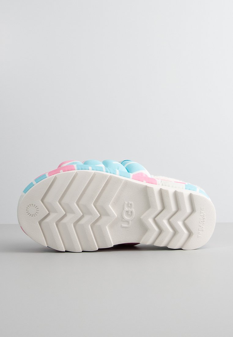 Calzature UGG colorate con una parte superiore morbida e testurizzata in rosa e blu, caratterizzate da una spessa suola in gomma bianca con un motivo a zigzag.