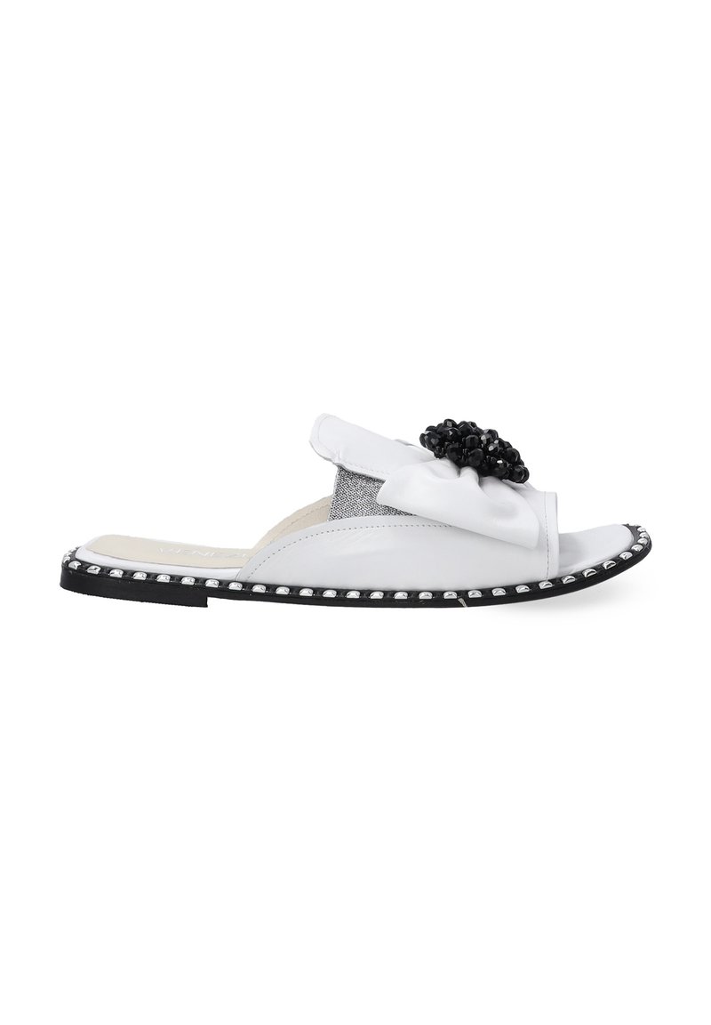 Witte leren slip-on sandaal met zwarte kralenbloemaccent. Kenmerkt zich door een geëtste grijze panel en zilveren studdetails langs de rand van de zool.