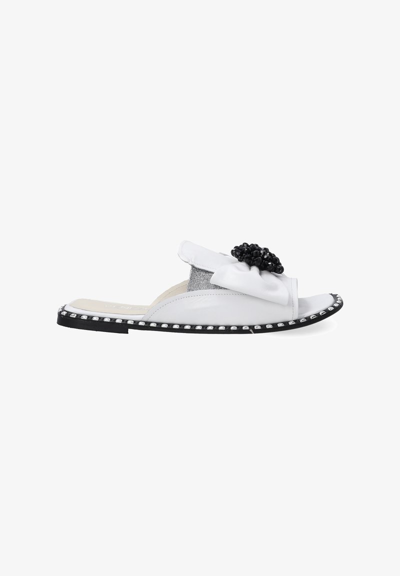 White leather slide sandal with black beaded floral accent. Features a textured gray panel and silver stud detailing along the sole edge.