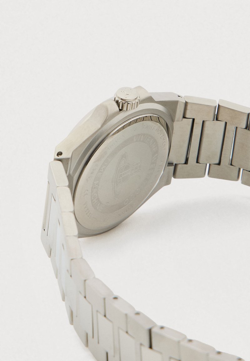 Silberne Metallarmbanduhr von hinten gesehen, zeigt graviertes Gehäuse, Krone und Gliederarmband vor weißem Hintergrund.