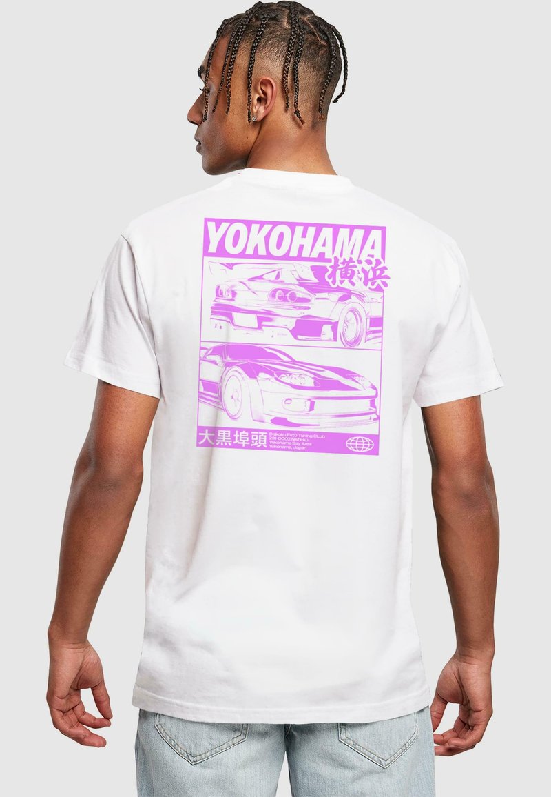 Hvid bomulds t-shirt med et stort pink grafisk motiv af to biler og japansk tekst på ryggen. Designet har kraftige konturer og minimal detaljering.