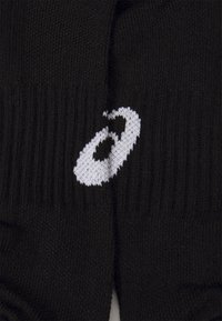 Sorte sokker med ribbestruktur og et hvidt logo. Designet har en sømløs strikfinish, der fremhæver holdbarhed og komfort.