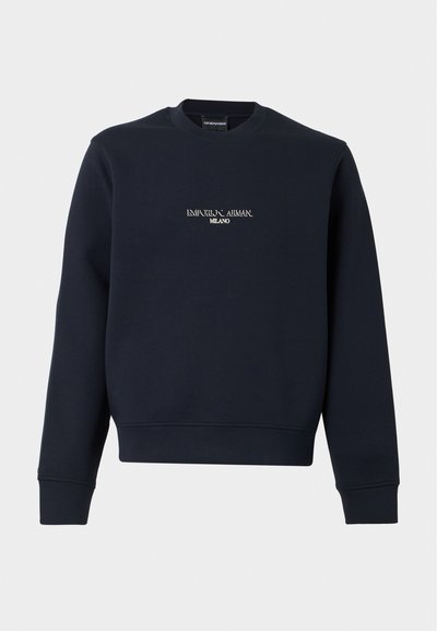 Μακρυμάνικη μπλούζα crewneck σε ναυτικό μπλε με το κείμενο "EMPORIO ARMANI MILANO" στο κέντρο του στήθους, σε λευκά γράμματα.