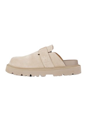 Zoccolo beige in suede con suola spessa e strutturata, cinturino regolabile con logo a cerchio cucito e tallone aperto.