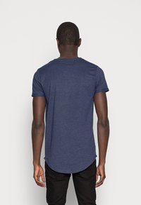 Mörkblå T-shirt med kort ärm och rundad nederkant, tillverkad av mjukt material, med klassisk rund halsringning och utan synliga logotyper eller mönster.