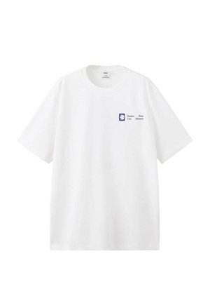 Camiseta blanca de manga corta con pequeño logo azul y texto negro "Études Pour Une Absence" en la parte superior izquierda del pecho.