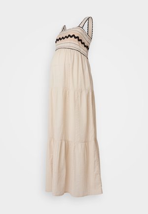 Maxikjole i cremefarvet stof, med lagdelt design, sort kant og teksturerede detaljer på bodice og nederdel. Spaghetti stropper.