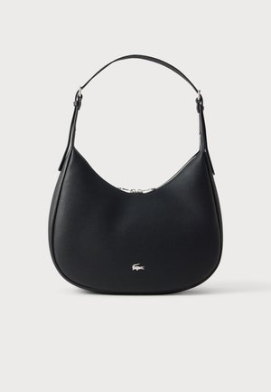 Sac à bandoulière en cuir noir avec forme courbée, emblème logo argenté sur le devant, et une seule sangle réglable.