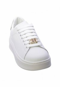 Sneaker bianco con upper in sintetico liscio, punta rotonda e lacci piatti. Presenta un accento dorato nell'area dei lacci e una suola spessa.
