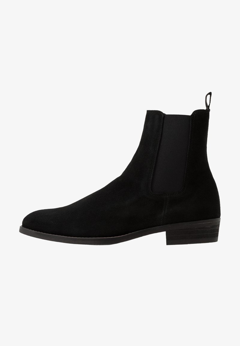 Svart mocka Chelsea-stövle med elastiska sidopaneler, rund tå, låg klack och en dragflik baktill för enkel påtagning.