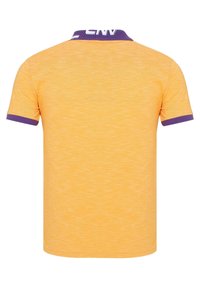 Geel polo shirt met korte mouwen en een gestructureerde afwerking, met een paarse kraag en mouwaccenten, en een "CNY" detail op de kraag.