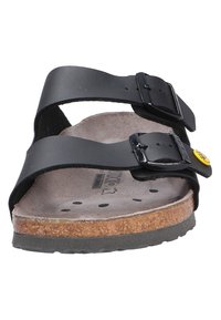 Black leather sandal with two adjustable straps, metal buckles, and a contoured cork footbed featuring ventilation holes. Rubber outsole.
