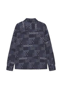 Long-sleeve shirt featuring a dark navy background with varied white patterns and designs, including geometric shapes and floral elements.