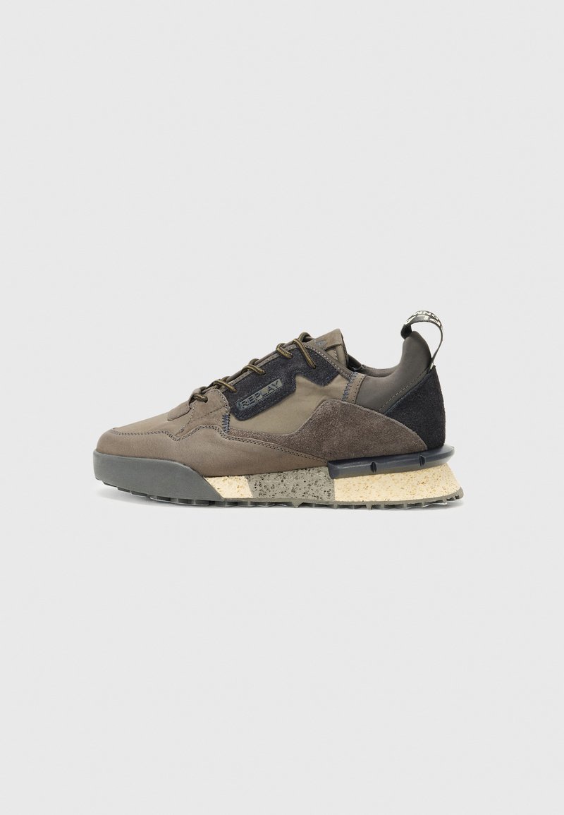 Männliche braune und schwarze Sneaker mit einem Obermaterial aus gemischtem Wildleder und Stoff, gesprenkelter beige und grauer Sohle sowie einem Markenaufhänger an der Ferse.