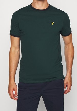 T-shirt court à manches courtes vert foncé avec un col rond, accents noirs et un petit logo jaune sur la zone de la poitrine gauche. Texture de tissu douce.