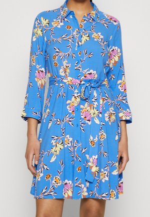 Niebieska sukienka na guziki z kwiatowym wzorem z żółtymi, różowymi i pomarańczowymi akcentami, z wiązaniem w talii i rękawami do połowy ramienia.