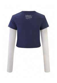 Maglietta cropped blu navy con maniche corte sovrapposte a maniche lunghe bianche. La parte posteriore presenta la scritta "Don Ed Hardy designs" in bianco. Tessuto morbido.