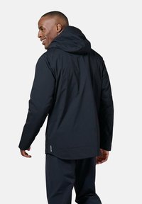 Zwarte waterdichte jas met capuchon, met een gladde textuur, lange mouwen en een licht gebogen zoom. Weergegeven vanuit een zij-achterhoek.