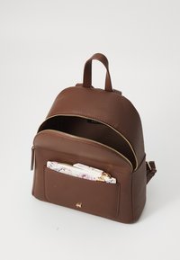 Zaino in pelle marrone con forma arrotondata, dettagli in zip dorate e una tasca frontale contenente una pochette con un motivo.