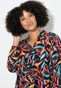 Blusa multicolore con un motivo astratto di pennellate arancioni, blu e rosa su sfondo nero. Lunghezza midi con colletto.