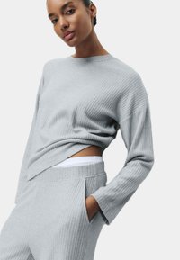 Lichtgrijze ribgebreide trui met een ronde hals, een losse pasvorm en lange mouwen, gecombineerd met bijpassende sweatpants met zakken.