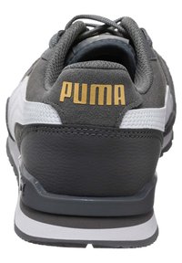 Pánské atletické boty s šedým semišovým svrškem, bílými koženými akcenty, silnou černou podrážkou a zlatým logem "PUMA" na patě.