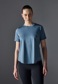 Blue short-sleeve athletic shirt made of smooth, lightweight fabric. Features a crew neckline and subtle side seams.