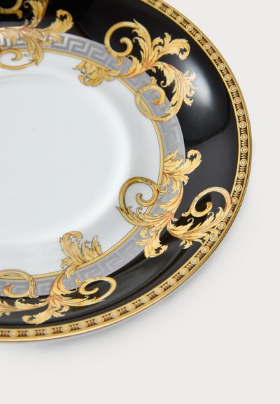 Μαύρο πορσελάνινο πιάτο με χρυσό και λευκό μοτίβο ελληνικού κλειδιού, διακοσμημένο με περίτεχνα χρυσά φύλλα κατά μήκος της χείλης και λευκό, λείο κέντρο.