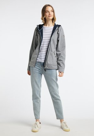 Grey zip-up jacket with navy accents, hood, drawstrings, and side pockets. Paired with a striped shirt and light wash jeans. White sneakers.