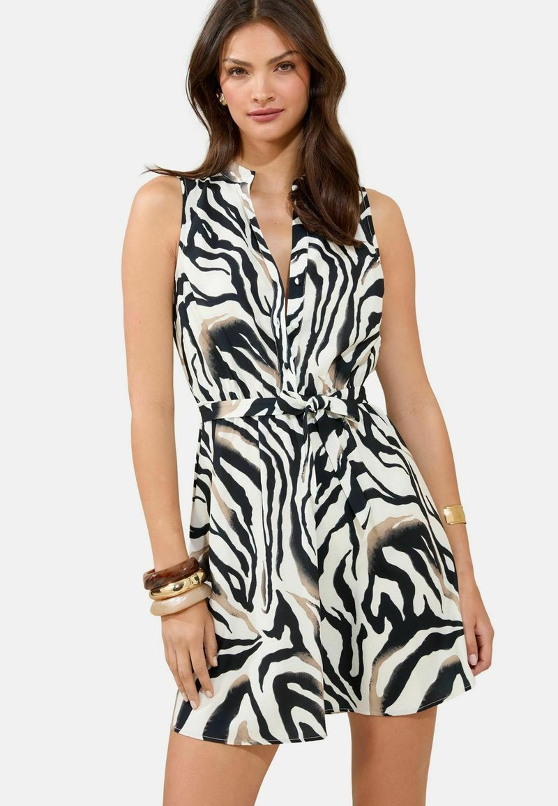 Abito senza maniche in stampa zebra bianco e nera, con una chiusura frontale a bottoni, vita regolabile con nastro e vestibilità comoda. Tessuto morbido con leggera lucentezza.
